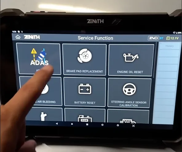 A finger selecting ADAS from the service function menu of a diagnostic scan tool.